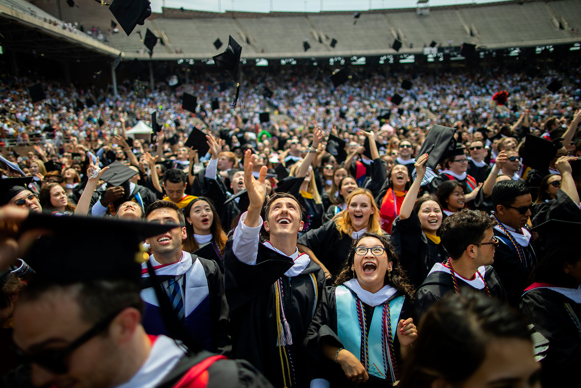 graduating students at commencment ceremony throwing their caps.